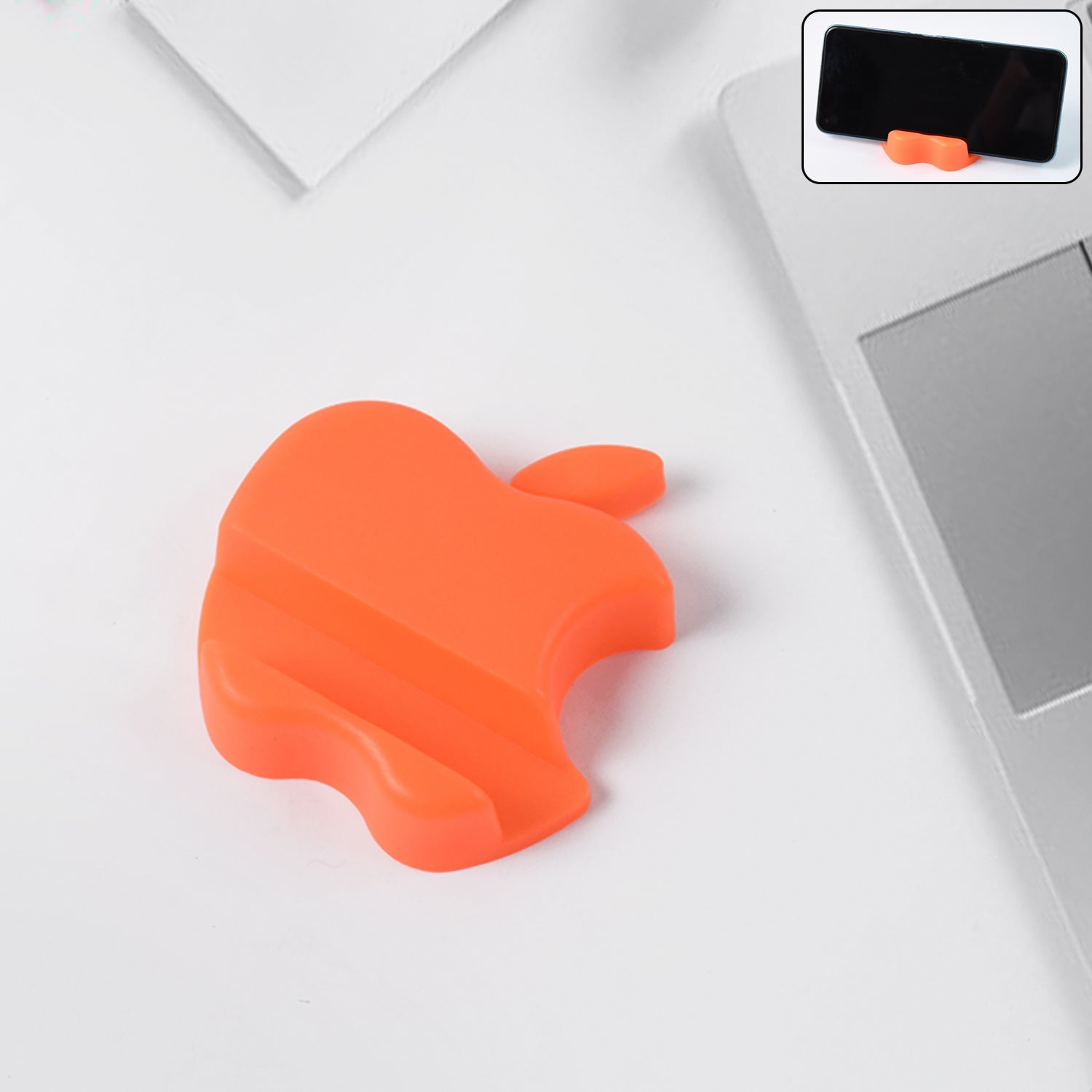 Apple-shaped plastic mobile phone holder in assorted colors on desk