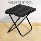 Folding Camping Stool set up in a lush green outdoor setting, ready for use.