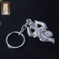 Silver metal Trishul Damru keychain shown on a white background
