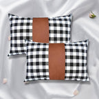 A pair of stylish leather and cotton cushion covers displayed on a modern sofa.