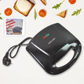 Dabster 2-slice sandwich maker with non-stick plates on a kitchen counter.