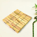 Strong bamboo cloth clips holding various garments on a clothesline, ideal for laundry.