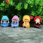 Close-up of resin monk Buddha figurines showing hand-painted details and serene expressions