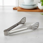 Serving tongs laid next to plates, ideal for serving snacks and salads