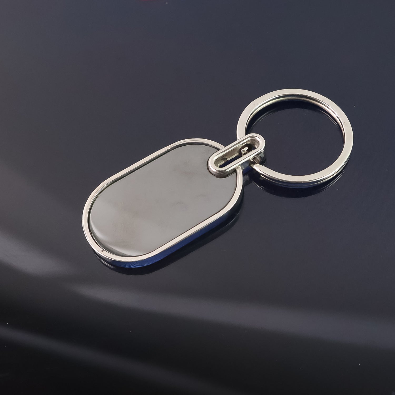 Compact oval metal keyring with black center and polished silver frame