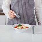 Close-up view of modern stainless steel salt and pepper shaker set