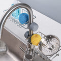 Stainless steel sink caddy organizer holding soap and sponge on kitchen sink