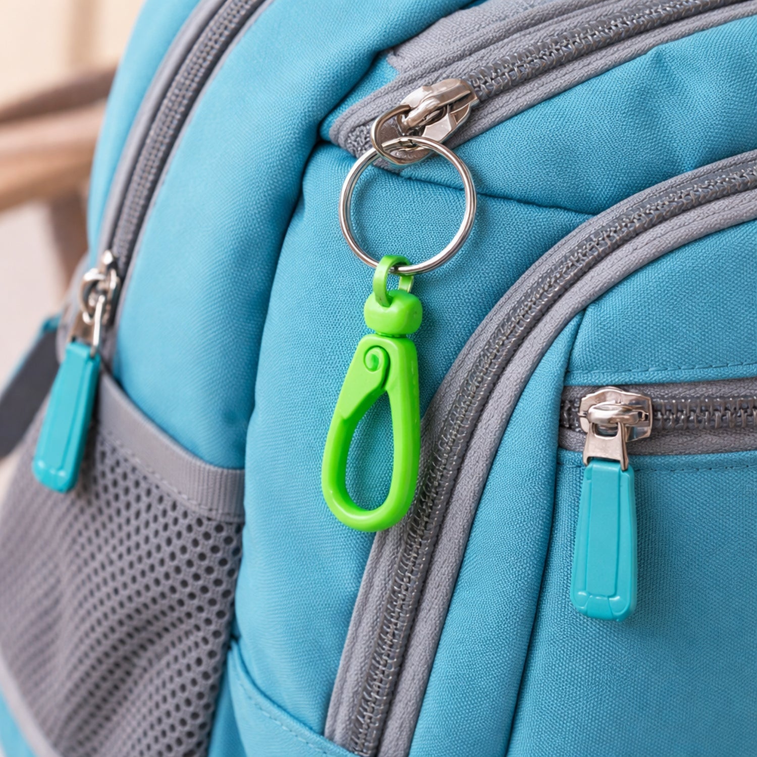Close-up of the mini plastic carabiner clip, highlighting its sturdy locking mechanism.