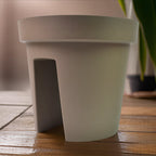 Creative flower pot holder mounted on balcony railing enhancing outdoor decor