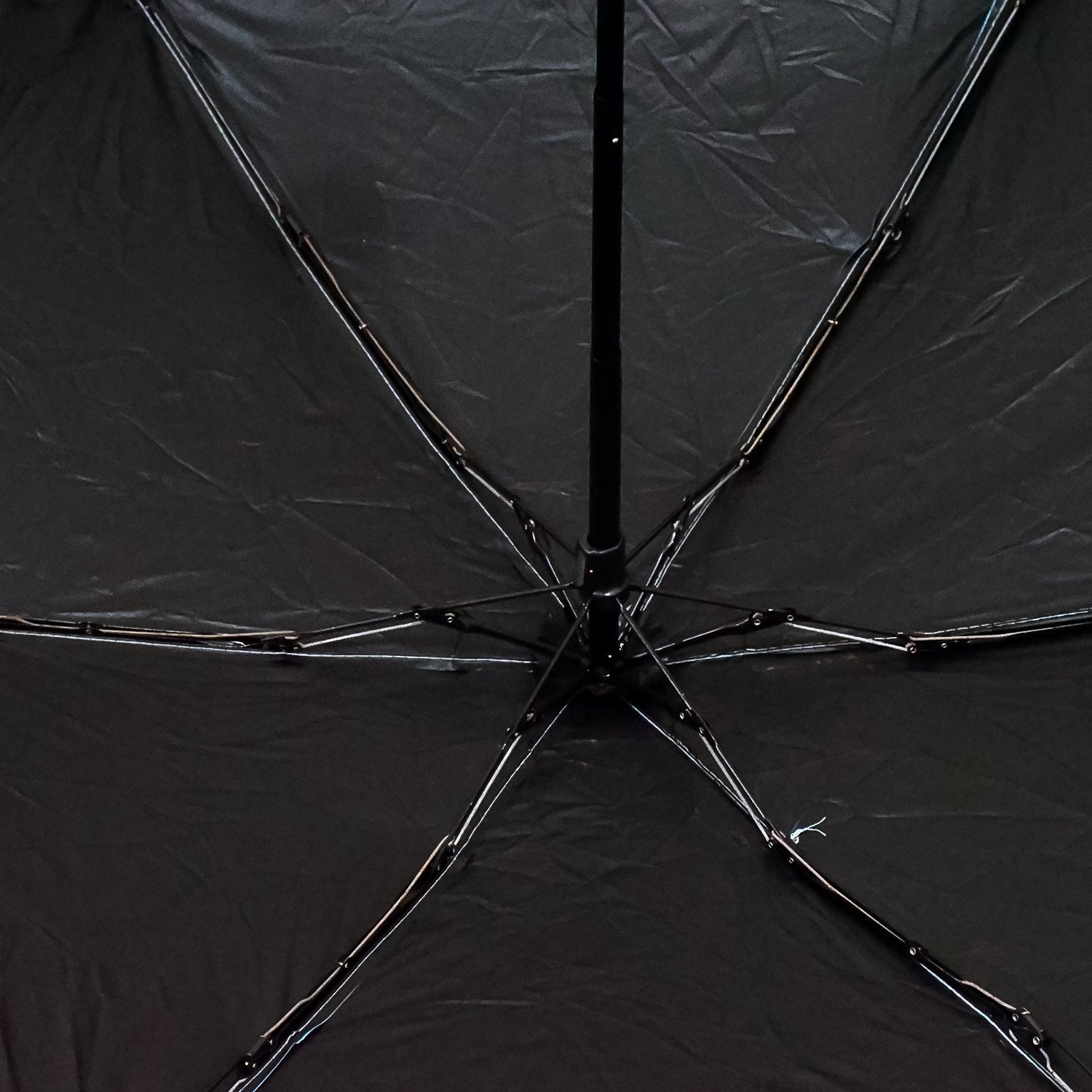 A DrizzlePro portable umbrella closed and ready to be stored, highlighting its compact design.