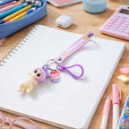 Bag accessory keychain with doll and cupcake charm on rainbow strap