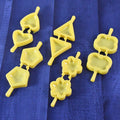 Plastic cookie cutter set with assorted shapes on a wooden table, ready for baking.