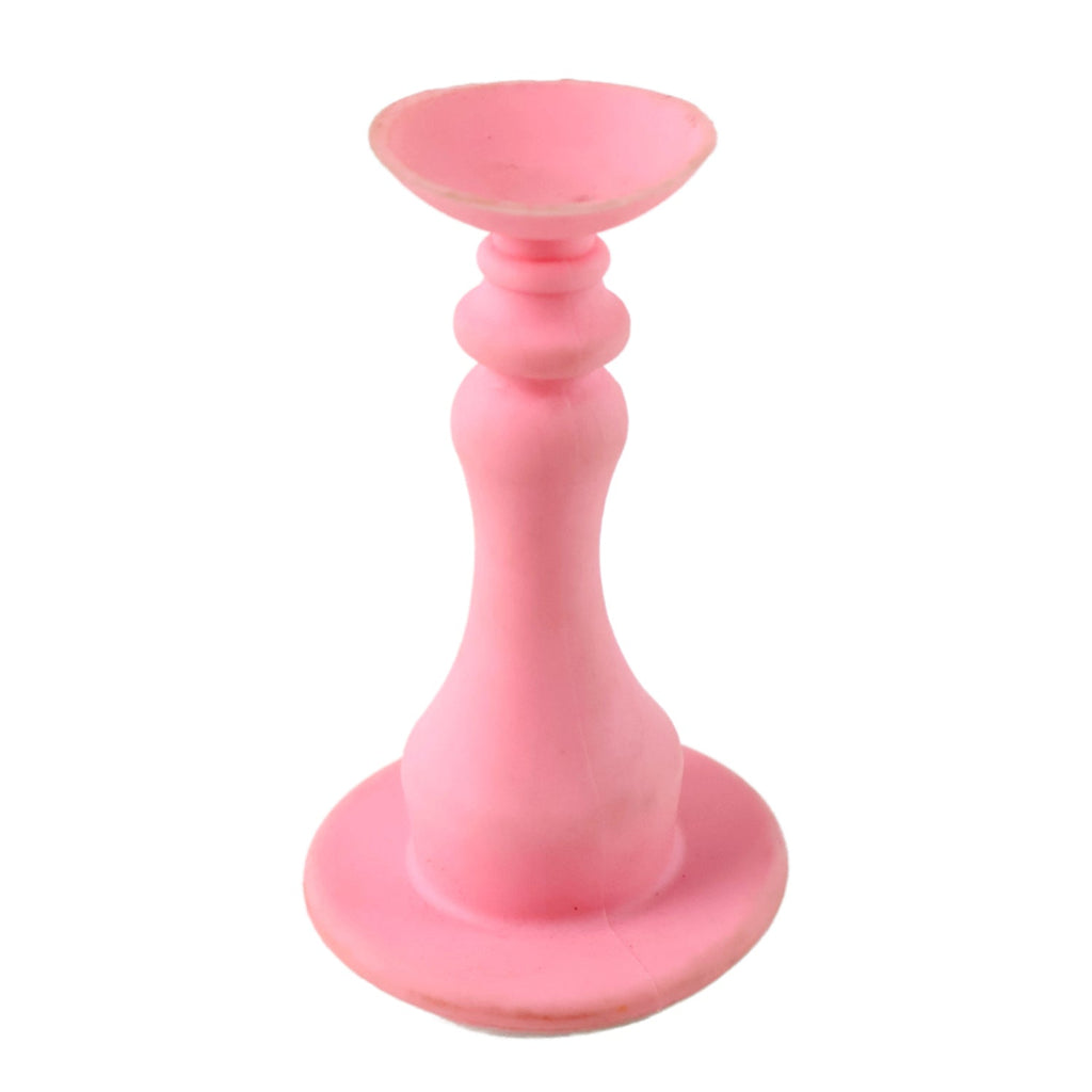 Hand holding pink washing machine door prop demonstrating use