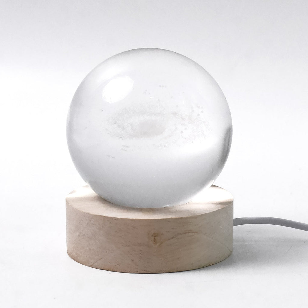 Hand holding the crystal sphere of the 3D Crystal Ball Lamp highlighting craftsmanship.