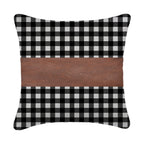 A set of contemporary leather pillow covers arranged on a comfortable armchair.