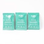 Cleaning kit components including refill sachets and spray bottle for glass surfaces.