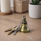 Close-up of the small ringing temple bell on the metal keychain, emphasizing detail.