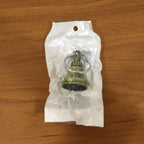 Metal temple bell keychain resting on a textured surface, showcasing its elegant form.