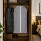 Lifestyle image showing the suit cover neatly hanging in a wardrobe for organisation.