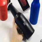 Lifestyle shot of the Audila Bottle Bluetooth Speaker being held outdoors.