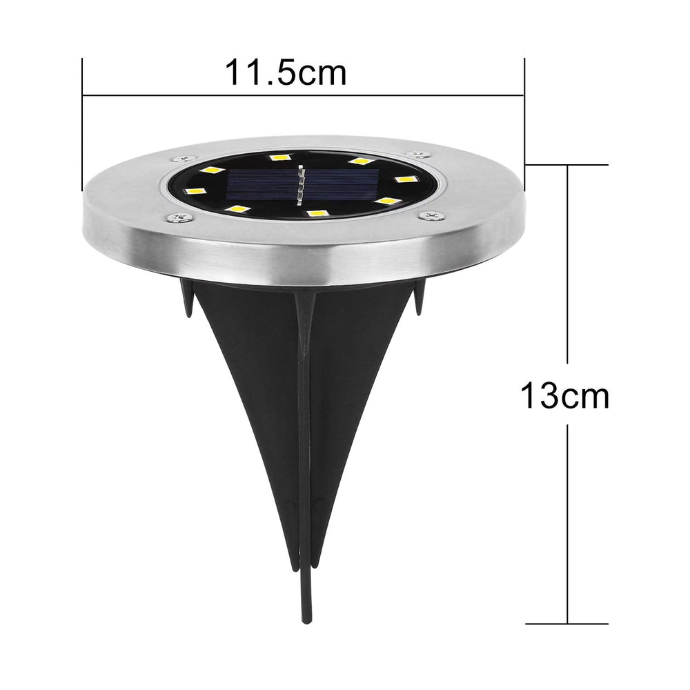 Single solar LED garden light glowing brightly at night in outdoor garden setting