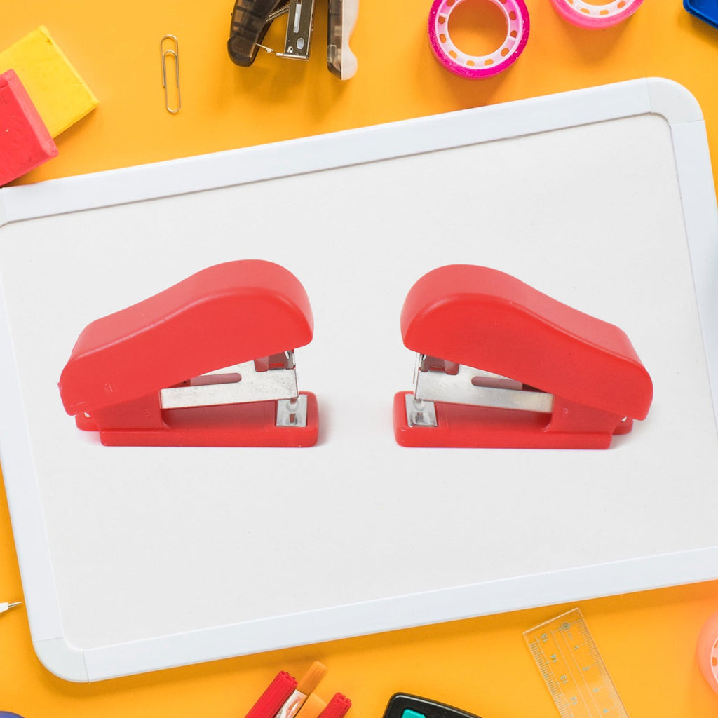Hand using a FiloDesk mini stapler to bind papers, highlighting its ease of use.
