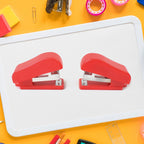 Hand using a FiloDesk mini stapler to bind papers, highlighting its ease of use.
