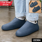 A person wears navy blue silicone shoe covers over their shoes, standing on a wet surface, with product details in the