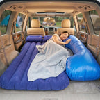 Couple relaxing on the inflatable car mattress inside SUV during camping trip