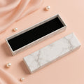 Luxury empty jewelry gift box with marble finish and black velvet interior, 21x5cm.