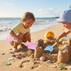 Kids playing with sand shovel and scoop tools at the beach