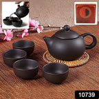 Matte black ceramic teapot alongside four matching ceramic cups