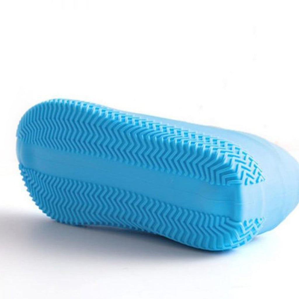 The bottom of a blue silicone shoe cover is visible, showing its prominent zig-zag textured sole for grip.