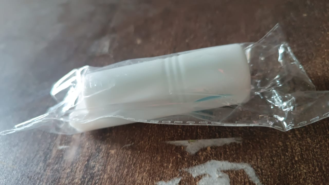 Lifestyle image of a hand holding the lint roller over clothing.