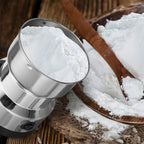 Hand operating the compact electric spice grinder with transparent lid.