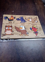 Wooden Bird Puzzle pieces laid out, ready for assembly by a young learner on the board.