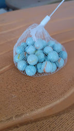 Classic white glass marbles with colorful swirls displayed for gaming and decor