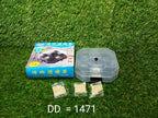 A blue box labeled "COCKROACH TRAP," a clear plastic trap, and three packets of bait are on a green artificial grass surface.