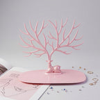 Front view of pink deer jewelry stand with earrings and rings, India