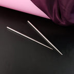 Stainless steel chopsticks elegantly holding food during a meal.