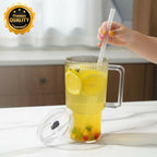 Glass tumbler with handle and reusable straw on white background