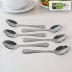 Set of six polished stainless steel dining spoons with elegant engraved handles
