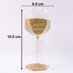Smooth yellow sand flowing inside an elegant glass hourglass timer.