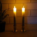 Pair of battery operated flameless LED taper candles glowing warmly during festival celebration