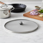 Stainless steel mesh food net lid covering fresh fruits and snacks.