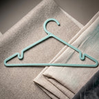 Plastic hanger holding shirt and dress, supporting heavy fabrics