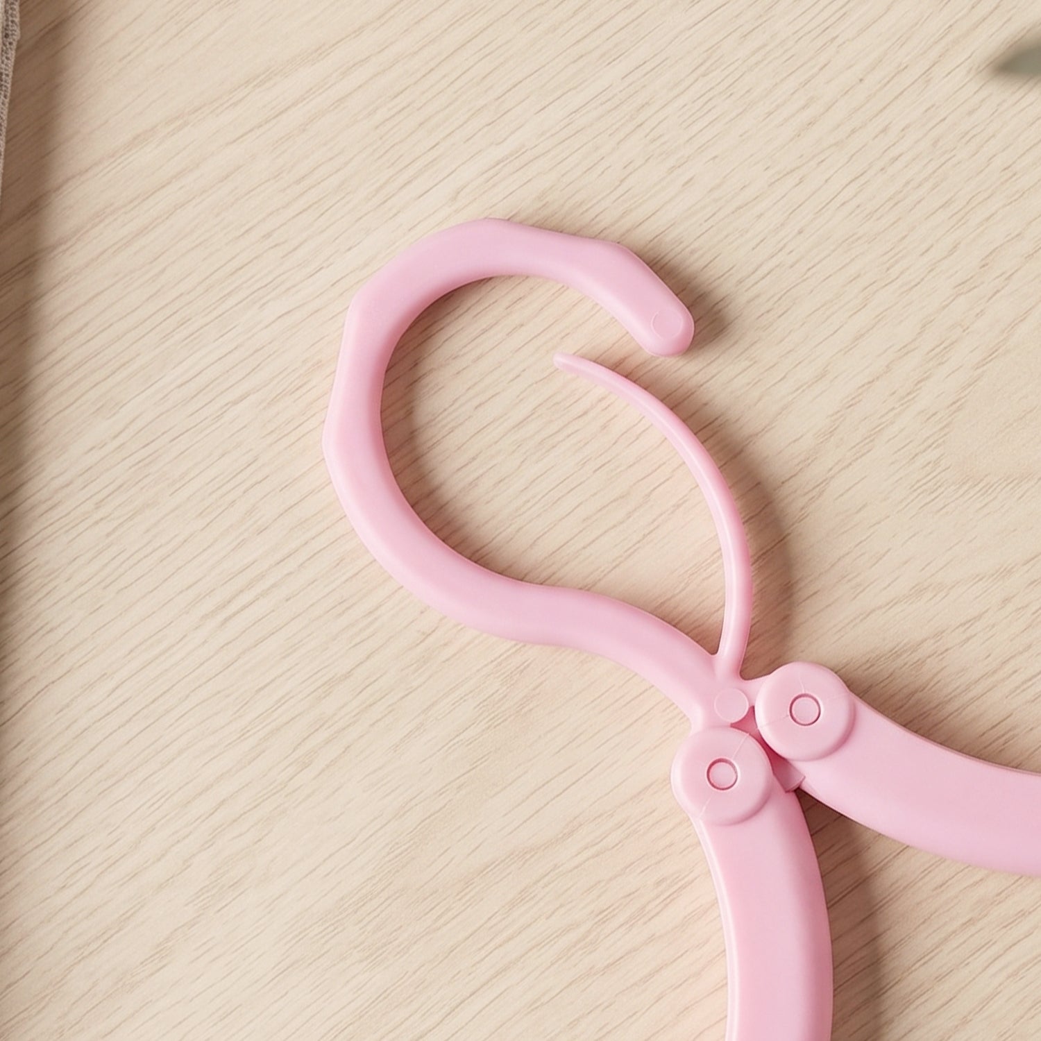 Folded clothes hanger fitting in travel bag pocket for space-saving