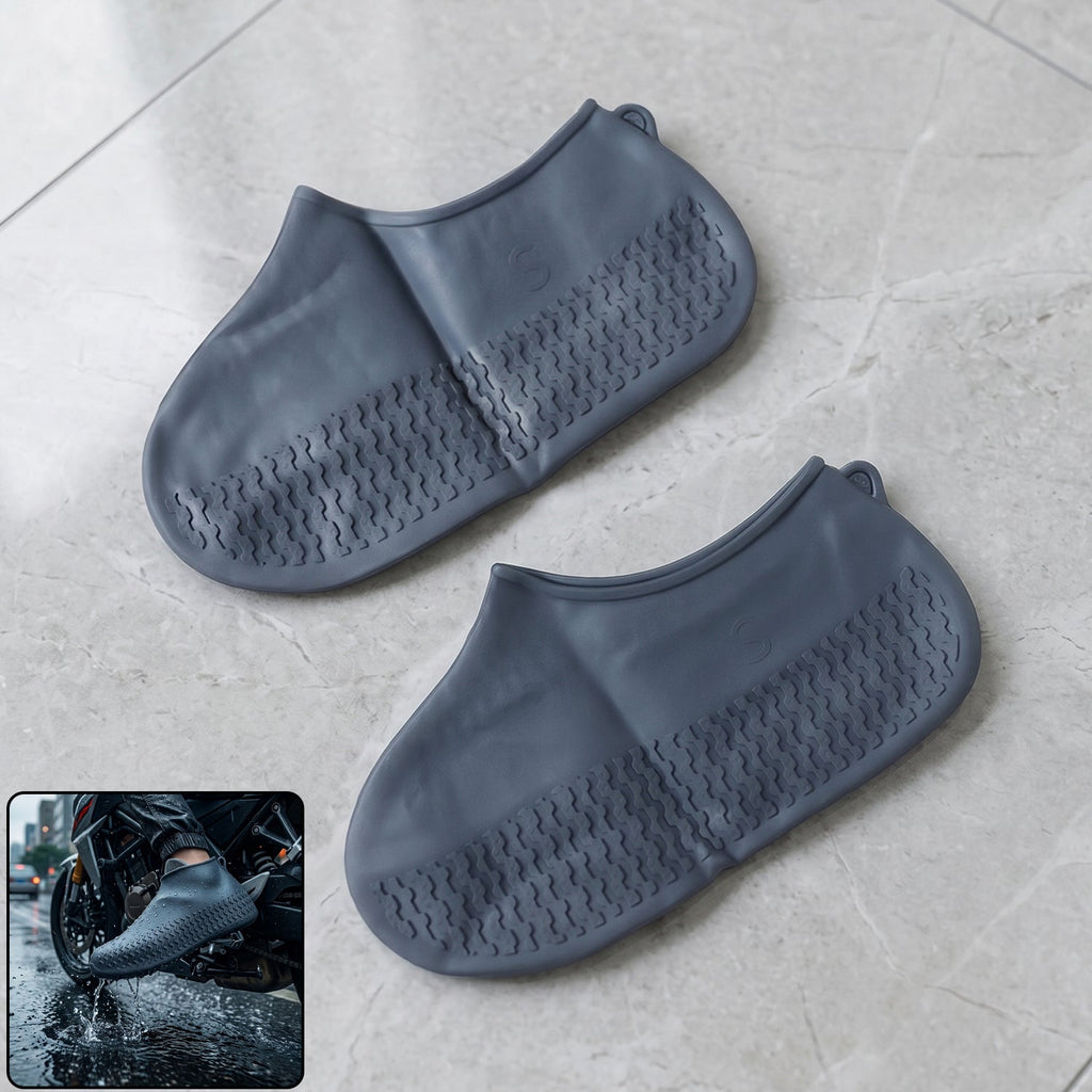 A pair of navy blue silicone shoe covers are displayed flat on a tiled floor, with an inset showing a person wearing one on