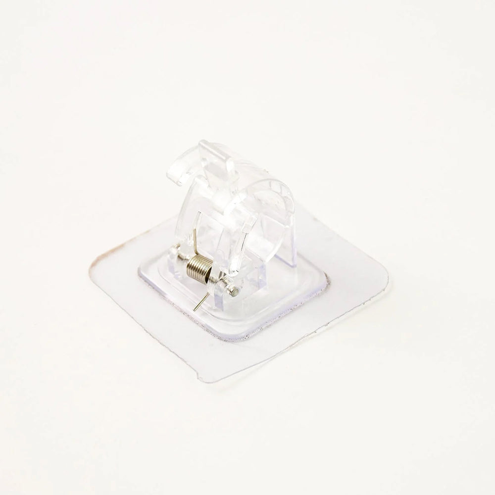 Self-adhesive curtain rail clip installed on wall for lightweight curtains
