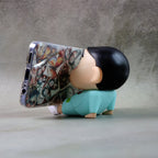 Mobile phone stand featuring a cartoon figurine design on desk